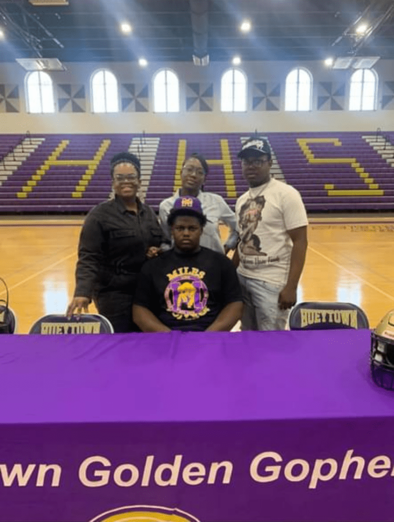 A Family Poses Together at a Basketball Court