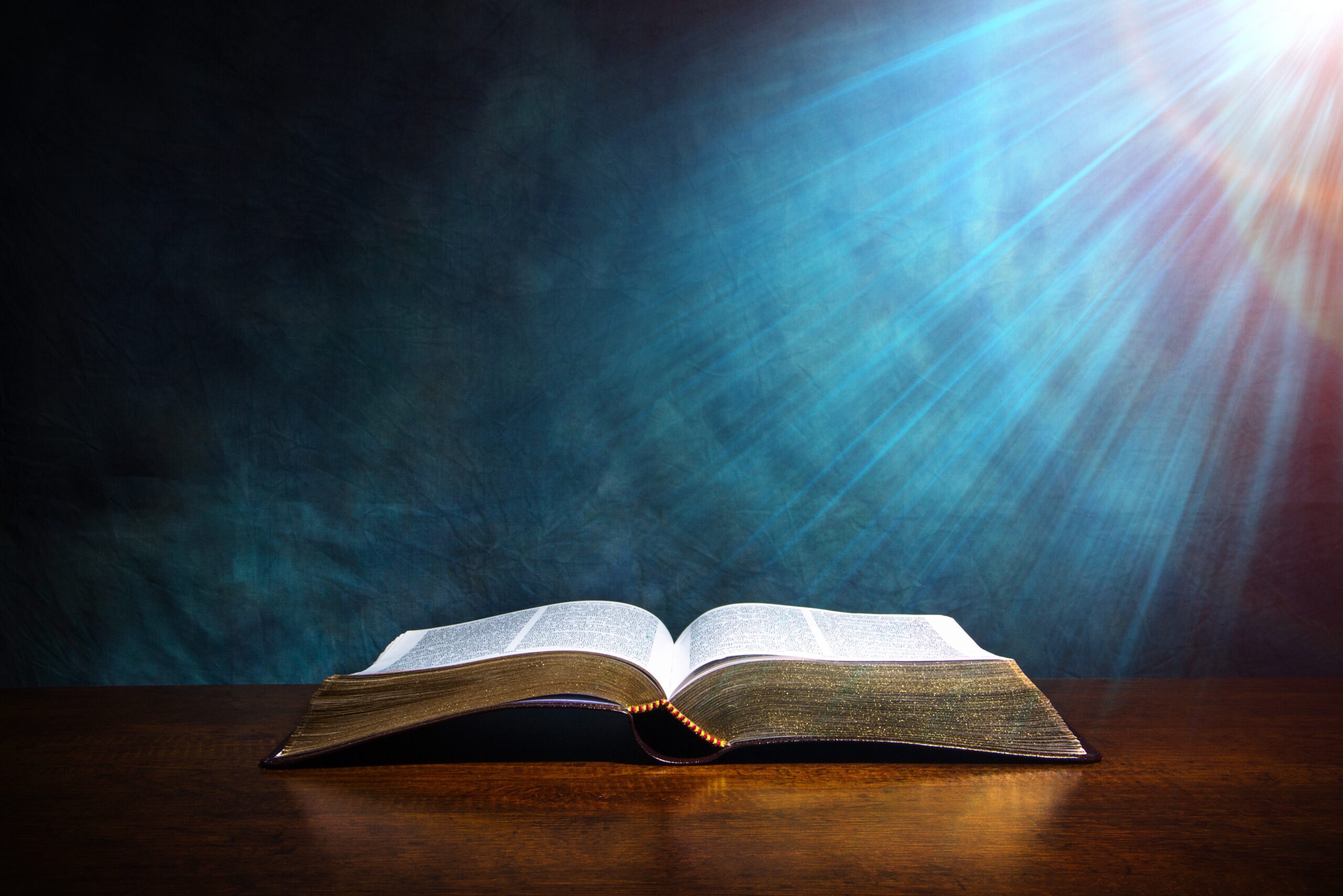 Open Bible on a Wood Table With Light